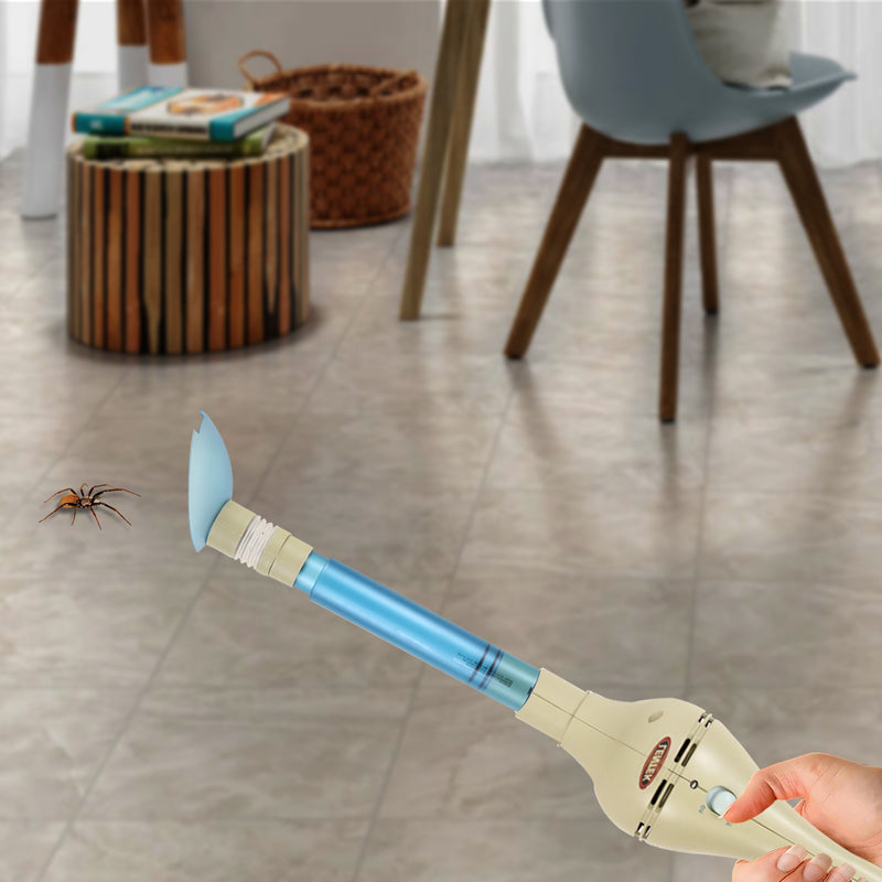 Hand holding the bug vacuum ready to catch a spider on a tiled floor with table and chair legs in the background