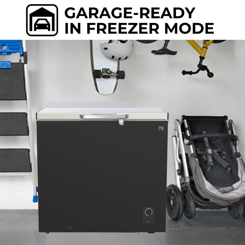 Kenmore convertible upright freezer/refrigerator, closed, in a garage with a light gray wall behind, blue metal barrel and shelves to the left, and white garage door to the right. Text above reads, "Garage-ready in freezer mode"