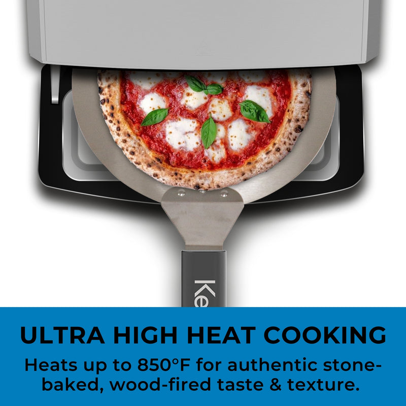 Top view of Kenmore indoor & outdoor countertop pizza oven with door open and pizza peel with a cooked pizza halfway out. Text below reads, "Ultra high heat cooking: Heats up to 850°F for authentic stone-baked, wood-fired taste and texture"