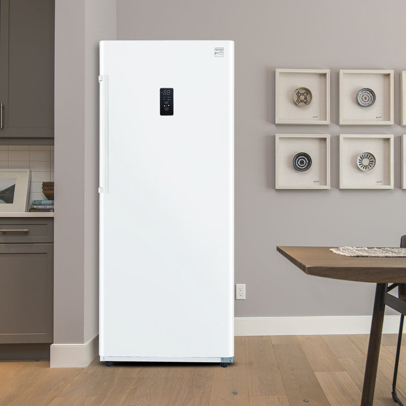 Kenmore convertible upright freezer/refrigerator, closed, in an eat-in kitchen with a light gray wall behind it, dark gray cabinets to the left, and a wood table in the foreground.