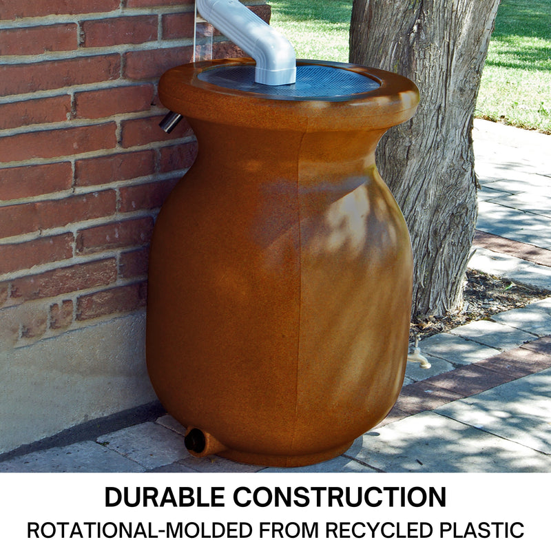 Koolscapes faux sandstone rain collector set up on a concrete path below a white downspout with a red brick wall, tree, and grass in the background. Text below reads, "Durable construction: Rotational molded from recycled plastic."